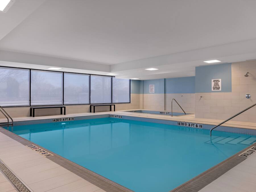 Una piscina con marcadores de profundidad visibles, tragaluz y suelo de baldosas.