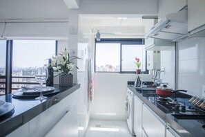 Appartement | Privékeuken | Een koelkast, een magnetron, een blender, kookgerei, borden en bestek