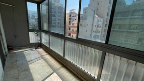 A room with a large window, tiled floor, and a ceiling vent. - New Jdeideh, Including Generator, Furnished Apartment, Parking, Great Location (Jdeideh)