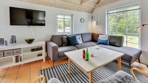 A modern living room with a sectional sofa, a flat-screen TV, and a dining table. - "Osmo" - 900m from the sea by Interhome (Ulfborg)