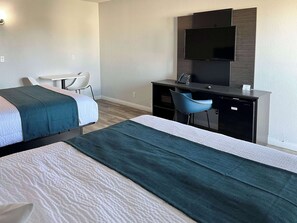 A hotel room with two beds, a desk, a chair, a TV, and a minibar. - Motel 6 Las Vegas, Nv – Downtown Fremont St (Las Vegas)