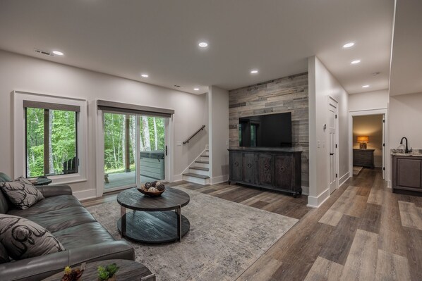 A modern living room with a leather sofa, a round coffee table, and a fireplace.