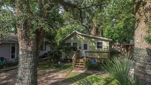 A small house with a porch, surrounded by trees. - Delightful 2-bedroom, 1-bath Home Near Biloxi's Scenic Back Bay (Biloxi)