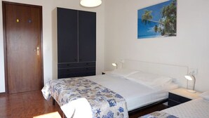 A bedroom with a bed, bedside tables, a wardrobe, and a wall-mounted picture. - Super Nice Apartment for 5 Guests With Pool and AC by Beahost Rentals (Caorle)