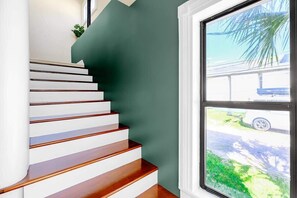 A staircase with white steps and a dark wall. - Aerie Loft: Cozy 1-bedroom Retreat in Biloxi, Perfect for Couples! (Biloxi)