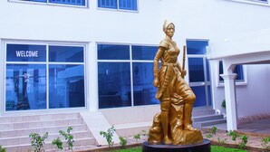 A building with a statue in front, a "WELCOME" sign, and a balcony with railings. - Hôtel Amazone (Cotonou)