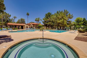 A swimming pool area with multiple pools, lounge chairs, and a building with a red roof. - Pool & Hot Tub Access! Extended Stay in Chandler (Chandler)