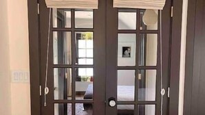 A dark wooden double door with glass panels and a white towel draped over the top.
