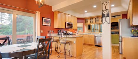 Enjoy meals in the kitchen with a central island, dining area, and large window offering a view of the outdoors.