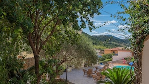A courtyard with stone flooring, outdoor furniture, and a pool. - Stunning Residence Bouganvillage Studio N1306 (Budoni)