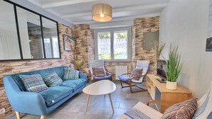 A modern living room with a blue sofa, a round white table, and two rocking chairs. - L'avocette - Damgan - Gîte (DAMGAN)
