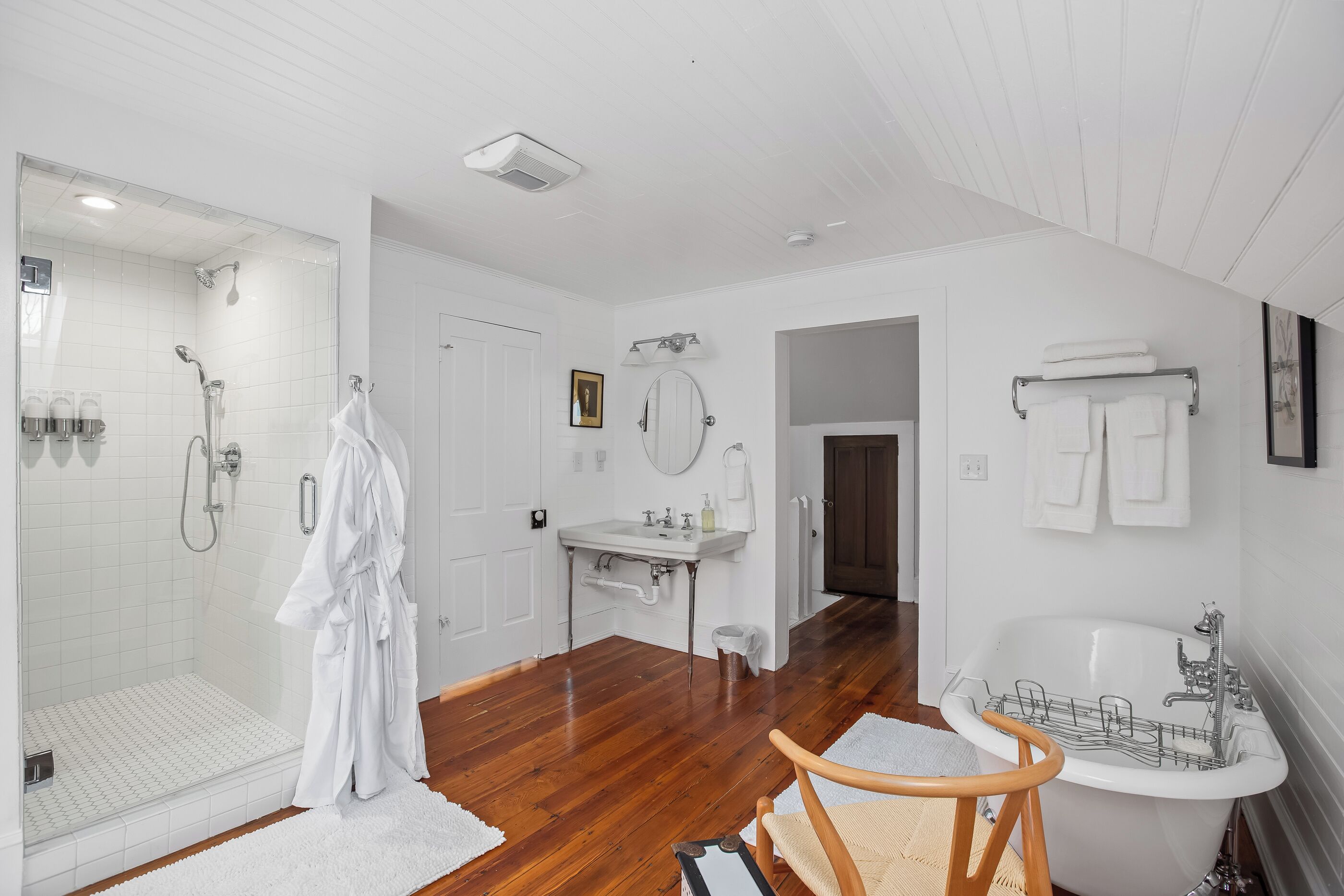 A modern bathroom with a glass shower, a white sink, and a bathtub.