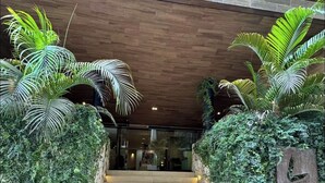 A staircase leading to a building entrance, flanked by lush greenery and a wooden ceiling. - Departamento con Jacuzzi en Playa del Carmen  (Playa del Carmen)