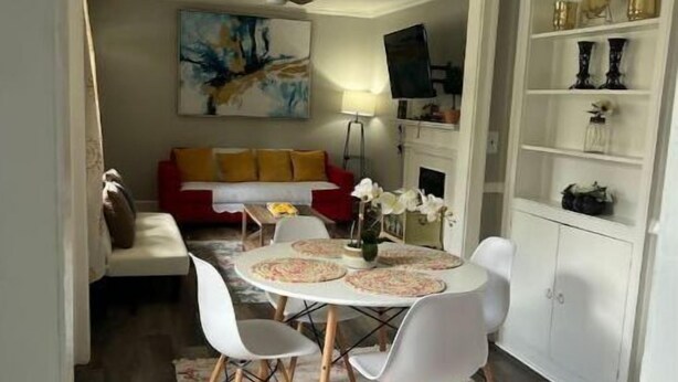 A dining area with a round table, white chairs, and a floral rug. - Cozy & Quite 2BR 1Bath Duplex Private Entrance Perfect for work Stays (Valdosta)