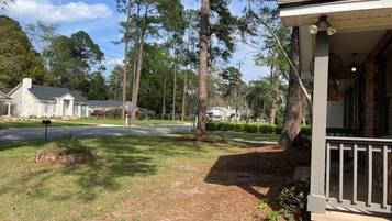 A residential street with houses, a porch, and a mailbox.