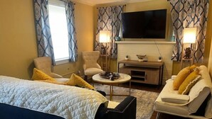 A hotel room with a bed, a sofa, a chair, a TV, and a small table. - Peaceful Private home near VSU, Down town & SGMC (Valdosta)
