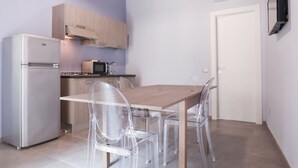 A compact kitchen with a refrigerator, microwave, and wooden cabinets. - Le Signorine Panoramic apts: Donna Rosina (Gratteri)