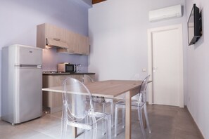 A compact kitchen with a refrigerator, microwave, and wooden cabinets. - Le Signorine Panoramic apts: Donna Rosina (Gratteri)