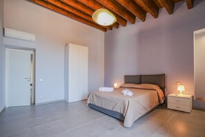 Ein modernes Schlafzimmer mit einem Bett, Nachttischen und einer Deckenleuchte.