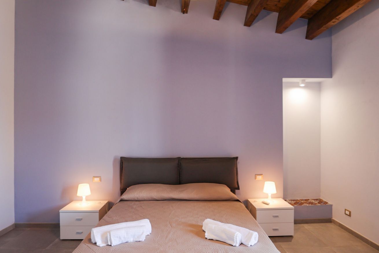 Ein Schlafzimmer mit einem Bett, zwei Nachttischen und einem Beistelltisch.
