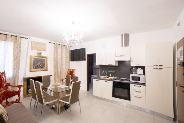 A modern kitchen with white cabinets, a built-in microwave, and a gas stove.