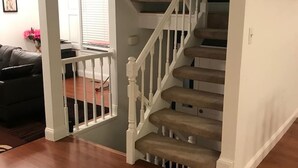 A staircase with white balusters and beige steps leading to a dark landing area. - Room in House - The Modern Gem Furnished Bedroom (Alexandria)