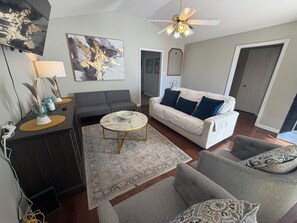 A living room with a sofa, armchair, coffee table, and decorative items.