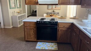 Una cocina con armarios de madera, estufa integrada y una pequeña isla con fregadero.