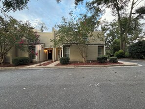 A two-story building with a 'No Parking Anytime' sign, a small entrance, and a driveway leading to the entrance.