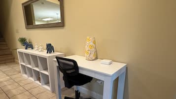 A home office with a desk, chair, and decorative items.
