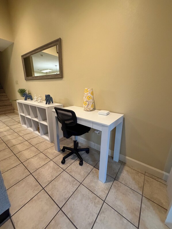 A home office with a desk, chair, and decorative items.