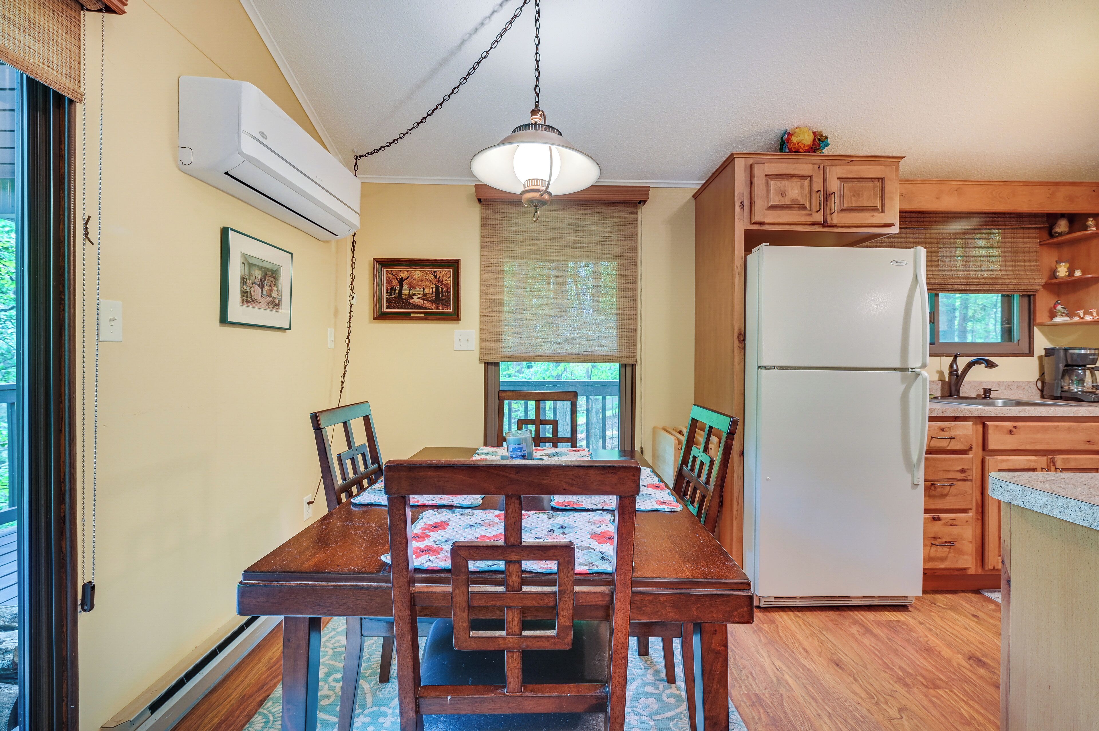 Una cocina con armarios de madera, un refrigerador blanco y una mesa de comedor con sillas.