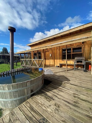A wooden building with a hot tub and a grill area. - Patagonia Puelo Lodge (Cochamó)