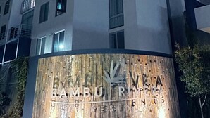 A multi-story building with illuminated signage reading "Bambu Rivera Resort."