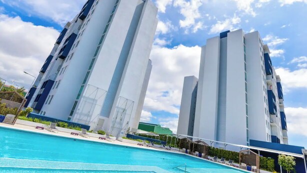 A modern building with a pool in front.