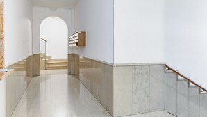 A modern interior with a marble staircase, a wooden bookshelf, and a clean, minimalist design. - GuestHost - Verona Central Apartment with Balconies! (Verona)
