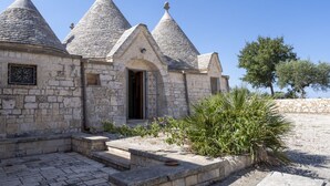 Un edificio de piedra con techos cónicos, una puerta y un pequeño jardín.