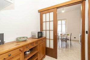 A kitchen with a microwave, a bowl, and a cabinet. - GuestHost - Functional apartment perfect for 4 guests located in a strategic and well-served position, in the heart of the Lingotto area, ideal for work, tourism and study. We are just a few minutes from the hospital area (Molinette, San Lazzaro Dermatol (Torino)