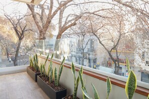 Ein Balkon mit Blumentöpfen und Blick auf die Stadtlandschaft.