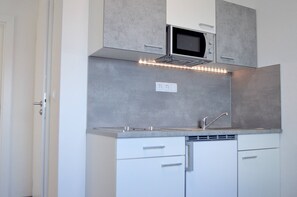 A modern kitchen with a microwave, built-in oven, and under-cabinet lighting. - Sea View Apartment Marijane, 940 (Preko)