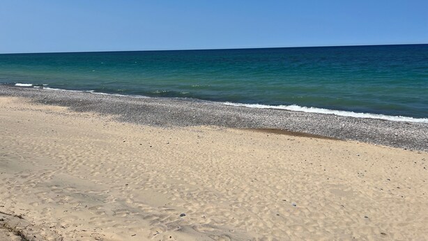 A beach with clear blue water and a sandy shore. - Cozy house ON the ATV/ORV trail located in Newberry.  Great for year round fun.  (Newberry)