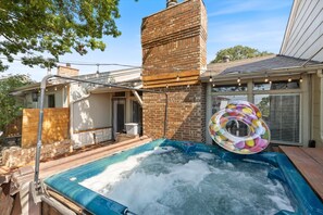 A hot tub with a colorful inflatable ring, a brick chimney, and a wooden deck. - Go jump in the Lake-Ray Hubbard (Rowlett)