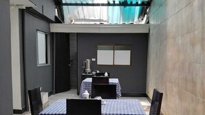 Quarto com toalha quadriculada, máquina de café e chão de azulejos.