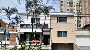 Um hotel com fachada moderna, entrada visível e área de estacionamento.