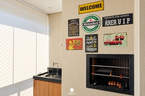 A kitchen with a built-in wine rack, a sink, and a window with a view. - Apto 100m da Praia Com Piscina Aquecida e Lazer - Cachoeira do Bom Jesus - Floripa (Florianópolis)