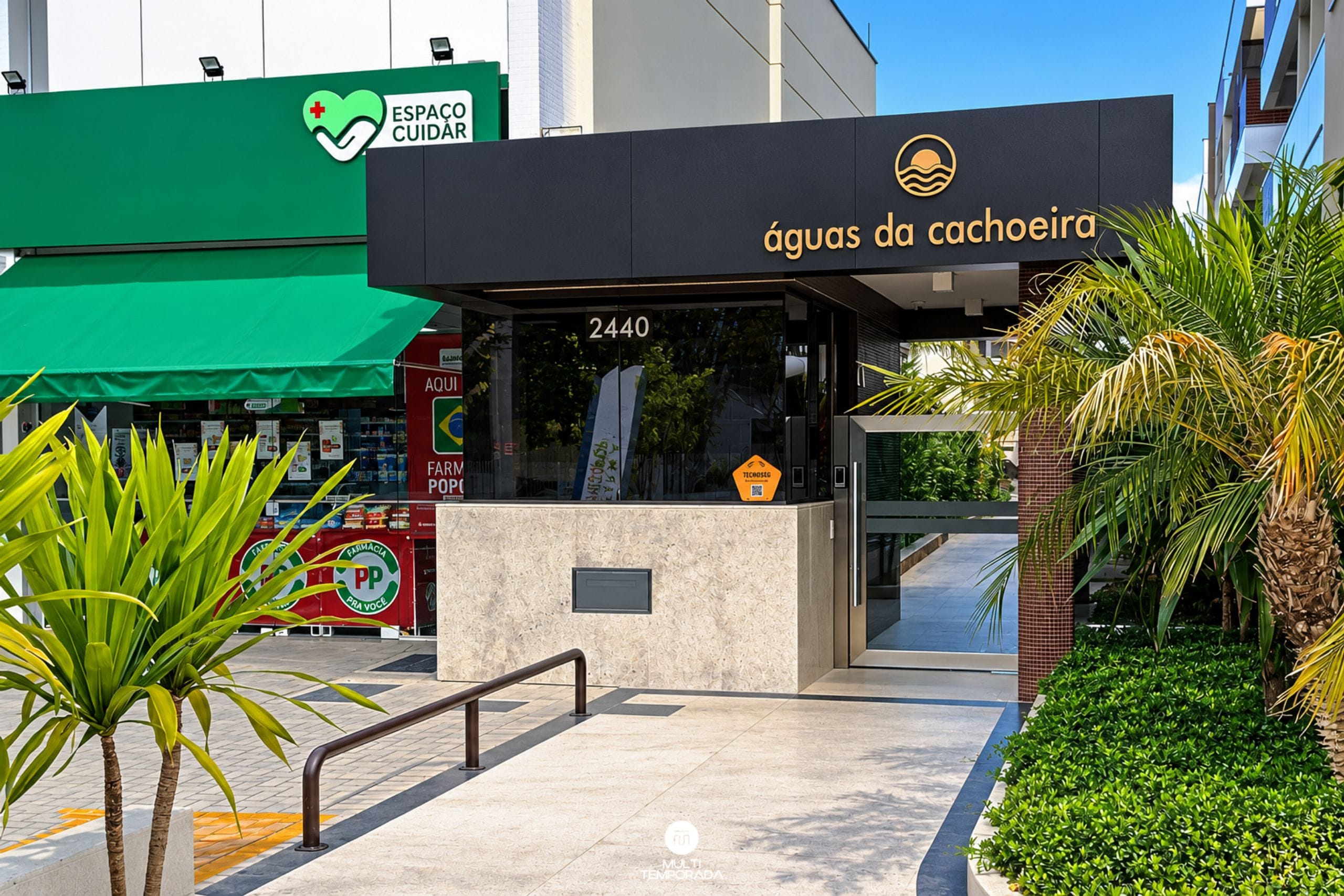 Een gebouw met een bord waarop 'águas da cachoeira' staat, en een apotheek met een rood en groen bord op de achtergrond.