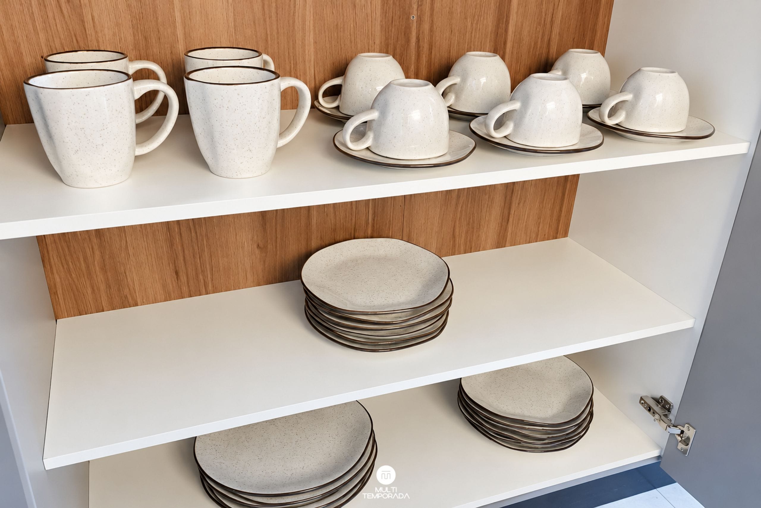 A kitchen with white shelves displaying ceramic mugs and plates.
