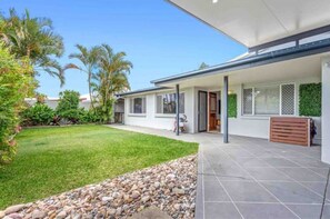 Enjoy a patio with a well-maintained lawn and lush plants, perfect for dining or entertaining.