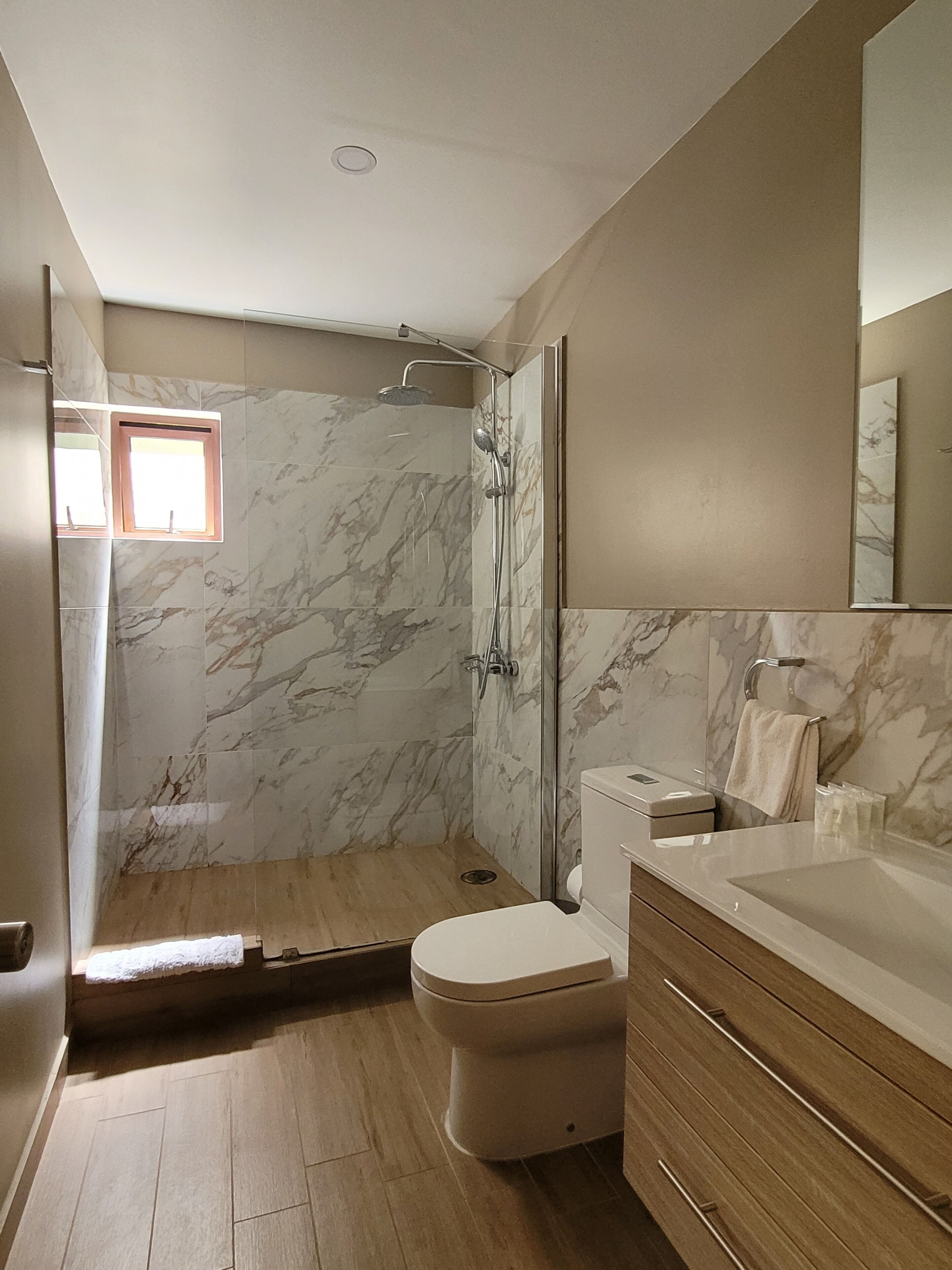 A bathroom with a shower, toilet, and vanity.