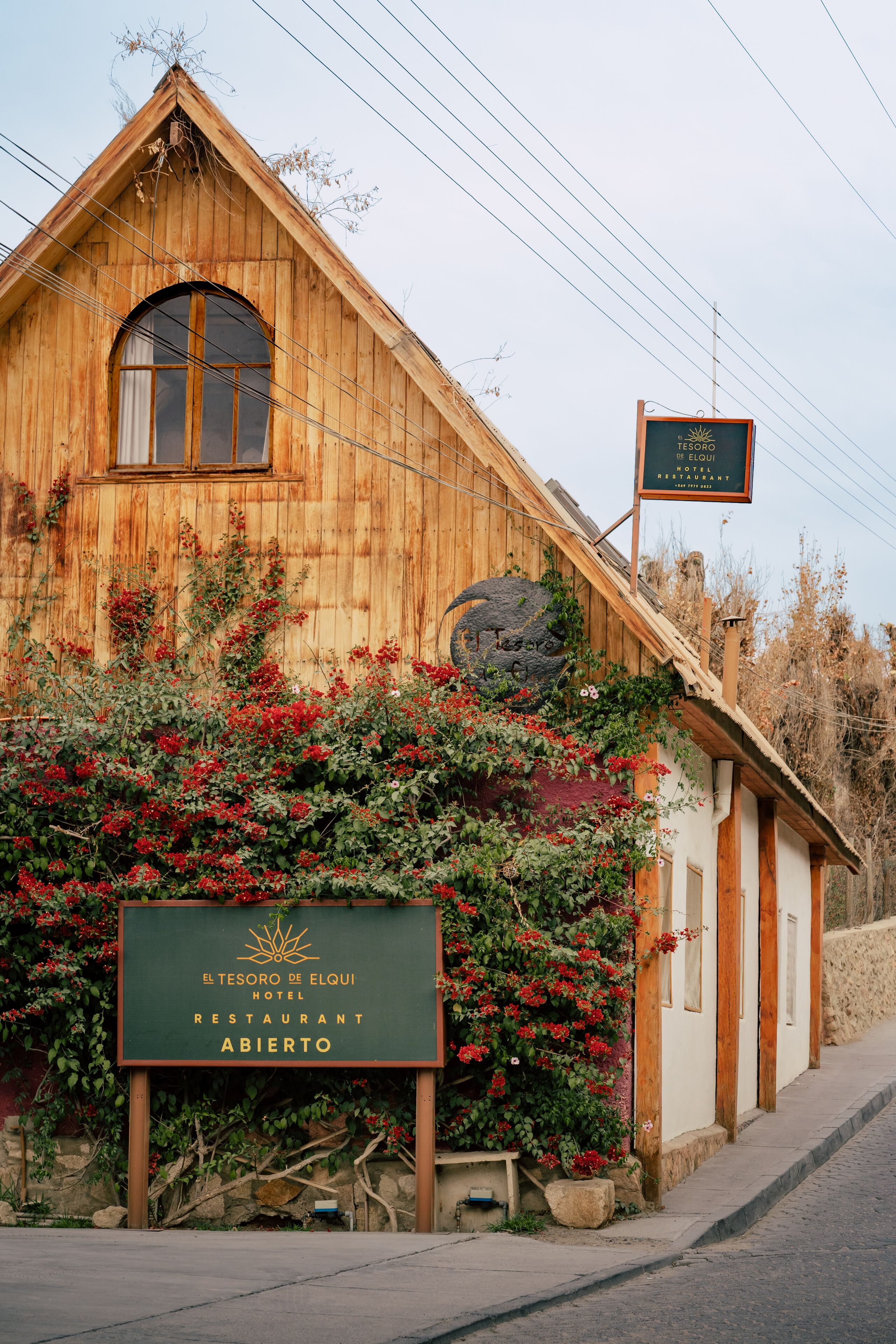 A wooden building with a sign indicating it is a hotel and restaurant.